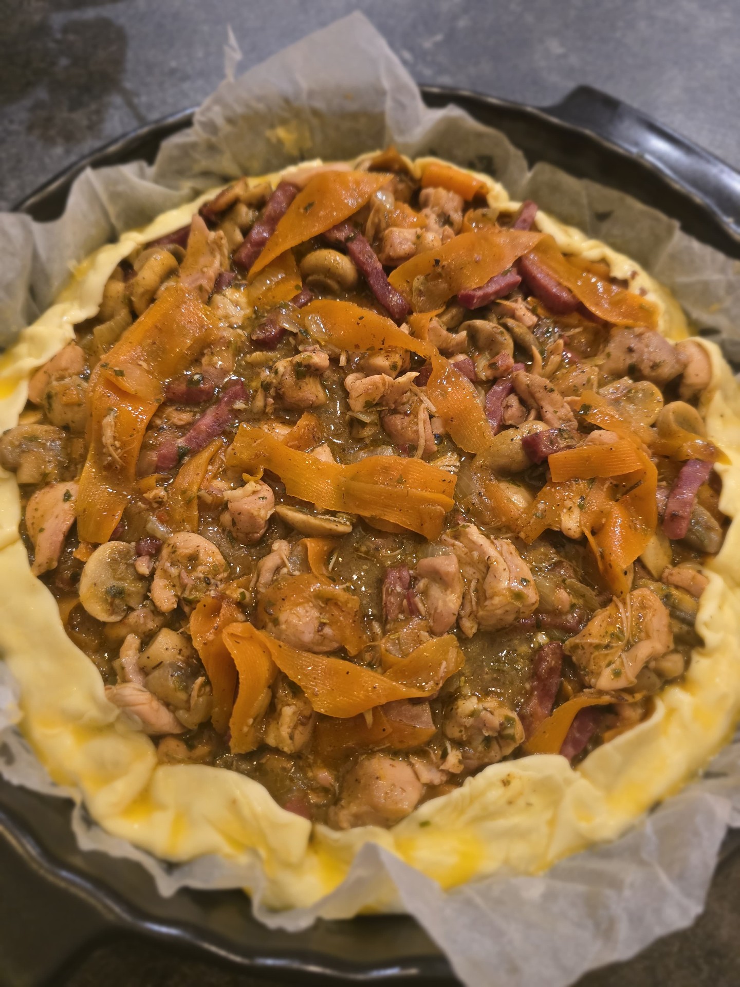Tourte au poulet, champignons et légumes en préparation